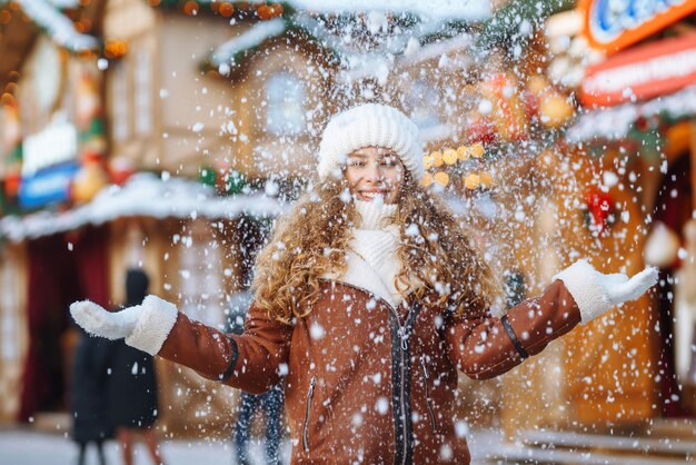 Photo belle femme marchant entre des stands décorés ou des kiosques dans le marché de noël concept de voyage