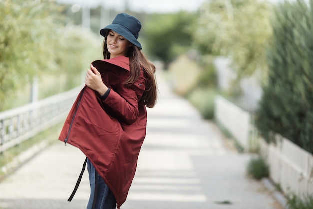 Belle femme marche dans l'allée dans un manteau d'automne.