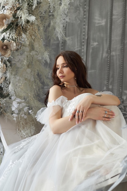 Belle femme mariée en robe de mariée blanche look romantique femme au repos Fabuleuse princesse élégante dame aux cheveux longs fond intérieur de style Loft