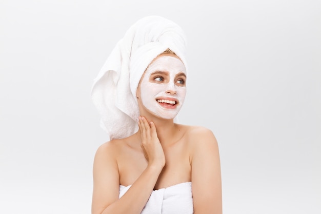 Belle femme avec un masque facial sur fond blanc