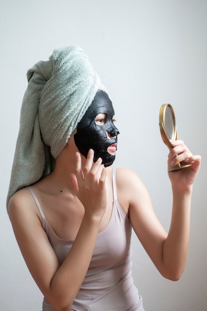 Belle femme avec masque facial noir, concept lifestyle