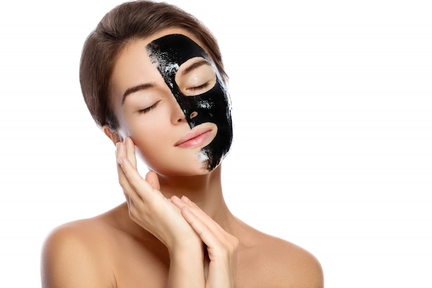 Belle femme avec un masque noir purifiant sur son visage