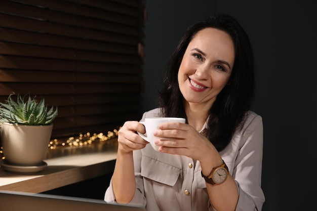 Belle femme mature avec une tasse de café à la maison