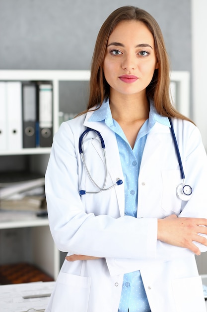 Belle femme médecin debout dans le portrait de bureau