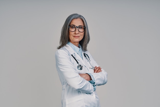 Belle femme médecin mature regardant la caméra et souriant