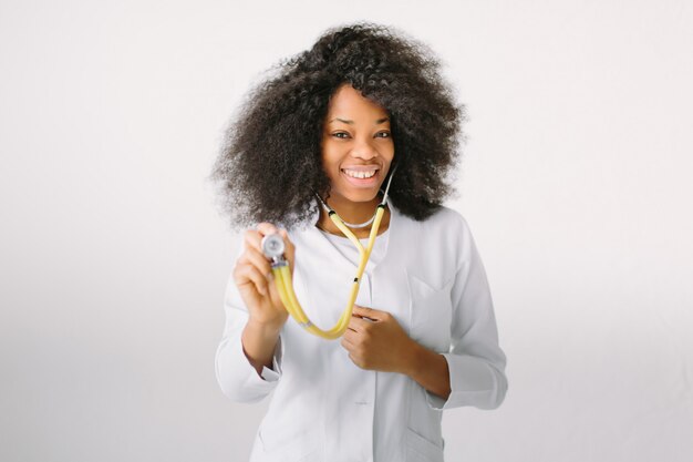 Belle femme médecin noire brésilienne avec un stéthoscope à l'hôpital sur fond blanc