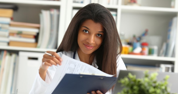 Une belle femme médecin noire souriante tient