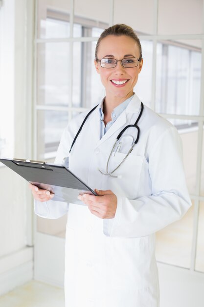 Photo belle femme médecin avec le presse-papiers à l'hôpital