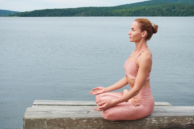 Belle femme méditant sur le fond d'un beau paysage marin