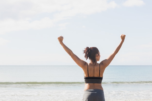 Belle femme mince qui s&#39;étend ses bras sur la plage