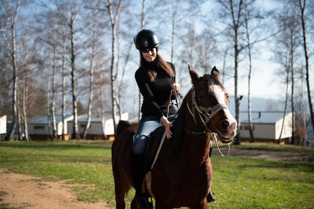 Belle femme monte un cheval portant un casque