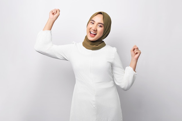 Belle femme musulmane asiatique arabe excitée portant le hijab célébrant le succès et regardant la caméra isolée sur fond blanc Concept de style de vie religieux des gens
