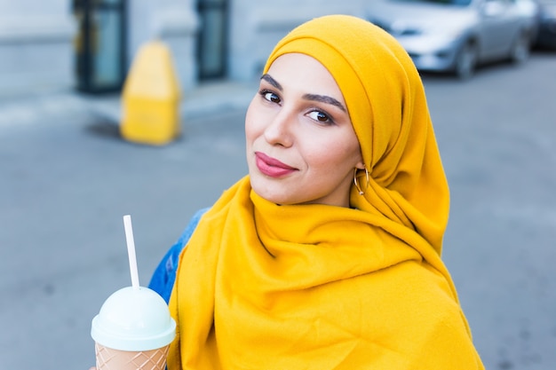 Belle femme musulmane avec café