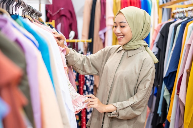 Belle femme musulmane avec foulard en regardant une robe