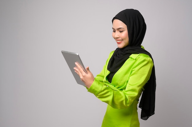 Belle femme musulmane avec hijab à l'aide d'une tablette sur le concept de technologie de fond blanc x9