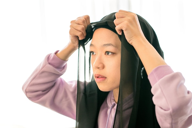 Belle femme musulmane mettant son foulard sur la tête