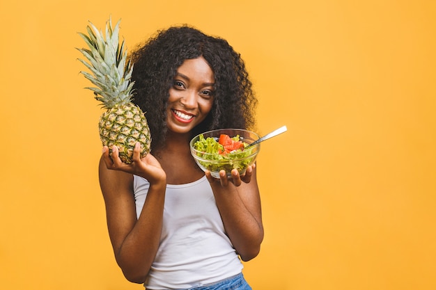 Belle femme noire afro-américaine manger de la salade et de l'ananas