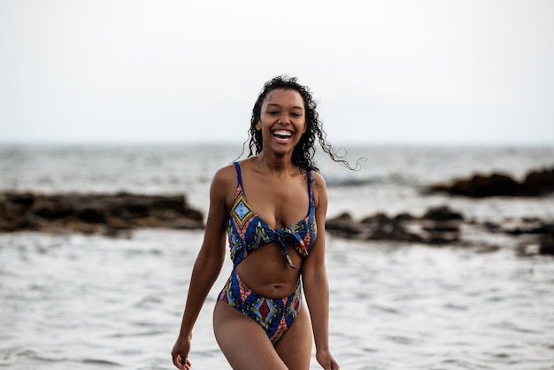 Belle femme noire ludique en forme de bikini sur une plage volcanique de Santo Antao, Cap Vert