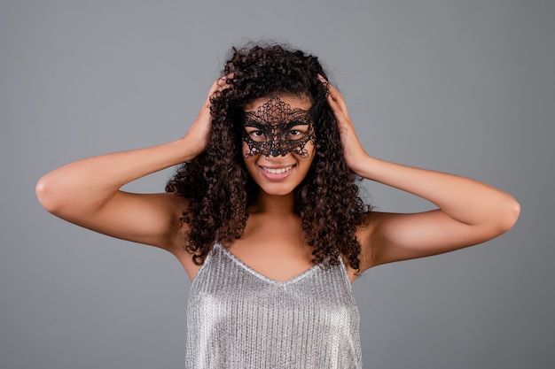 Belle femme noire portant un masque de mascarade élégant isolé sur fond gris