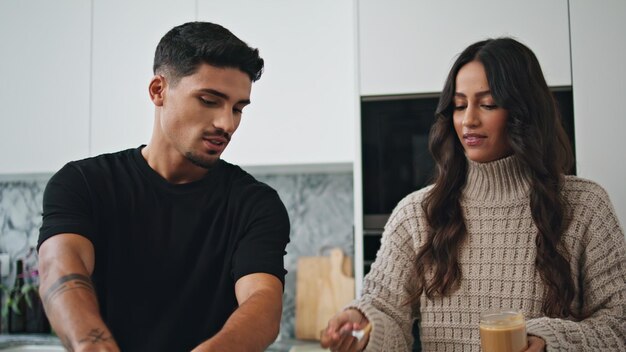 Photo une belle femme nourrit un homme à l'intérieur blanc en gros plan. une famille mange dans une maison confortable.