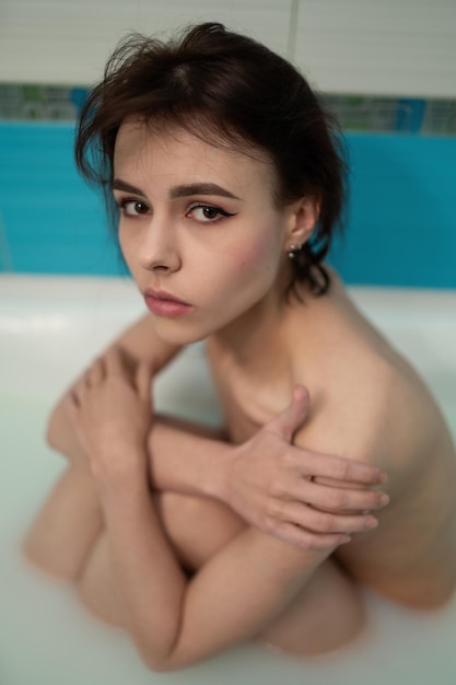 Belle femme nue est assise dans le bain