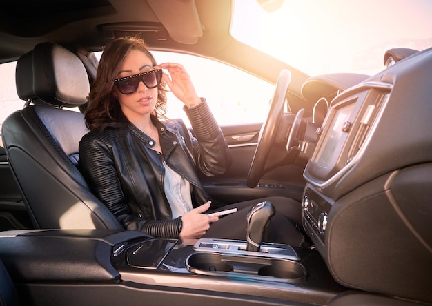 Belle femme parlant au mobile à l'intérieur d'une voiture