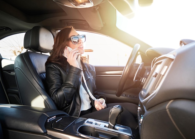 Belle femme parlant au mobile à l'intérieur d'une voiture