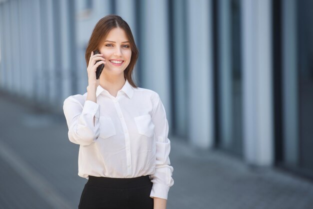 Belle femme parlant sur un téléphone portable dans le centre-ville