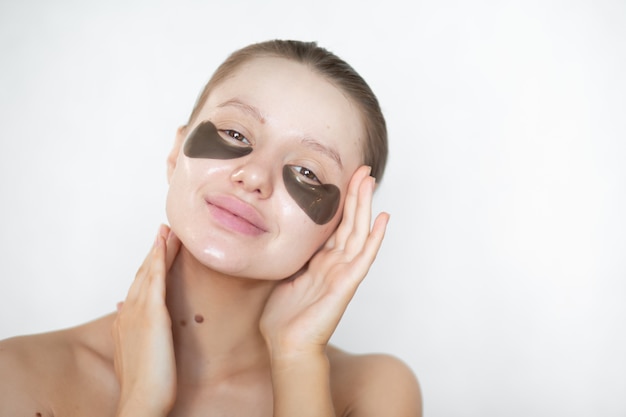 Belle femme avec des patchs oculaires hydrogel sur son visage