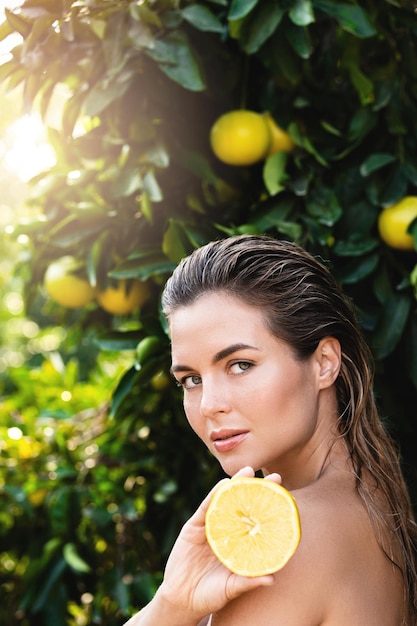 Belle femme à la peau lisse avec un citron dans les mains