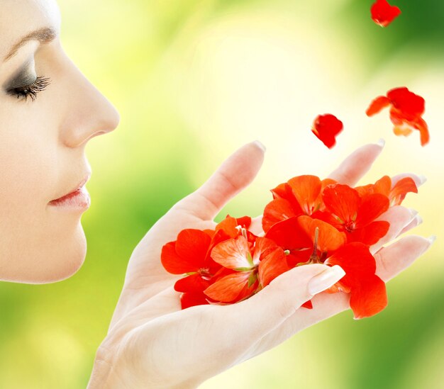 Photo belle femme avec des pétales de fleurs rouges au spa