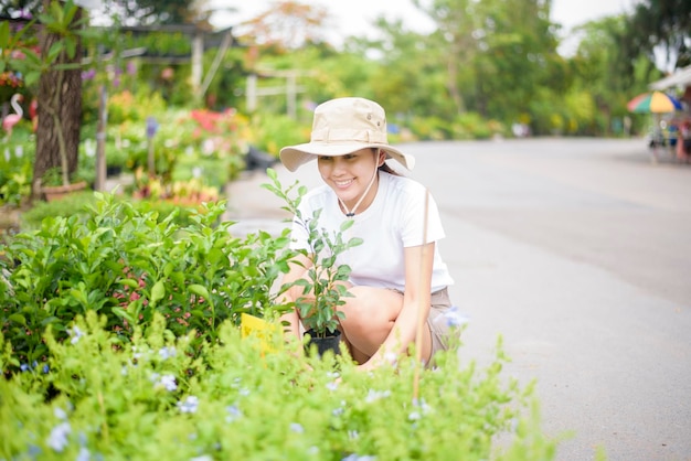 Belle femme avec une plante de jardinage dans le jardin