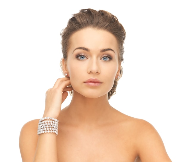 belle femme portant des boucles d'oreilles et un bracelet en perles