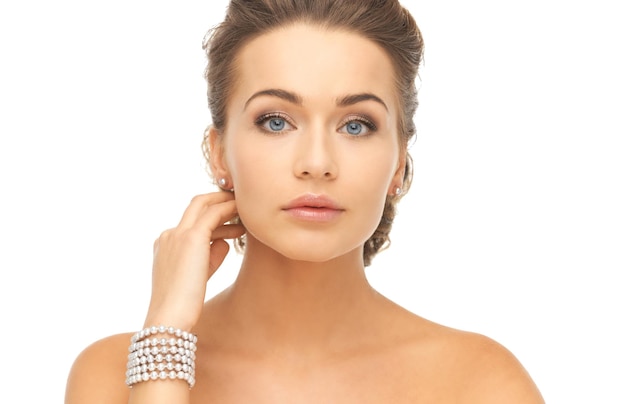 belle femme portant des boucles d'oreilles et un bracelet en perles