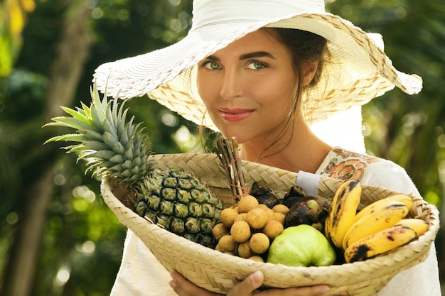 Belle femme portant un chapeau à large bord dans le jardin tropical