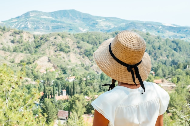 Belle femme portant un chapeau de paille à la vue sur la vallée