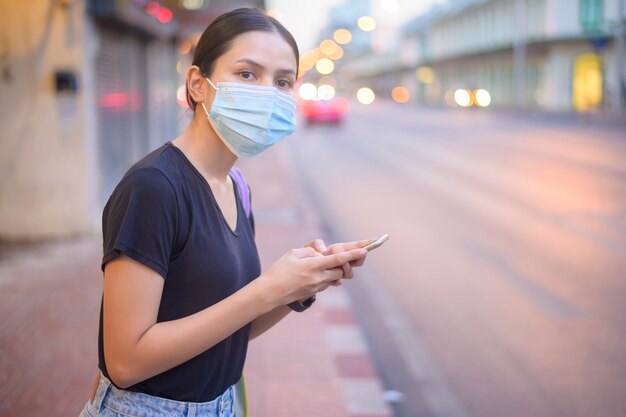 Belle femme portant un masque chirurgical extérieur, covid-19, concept de santé et de pollution.