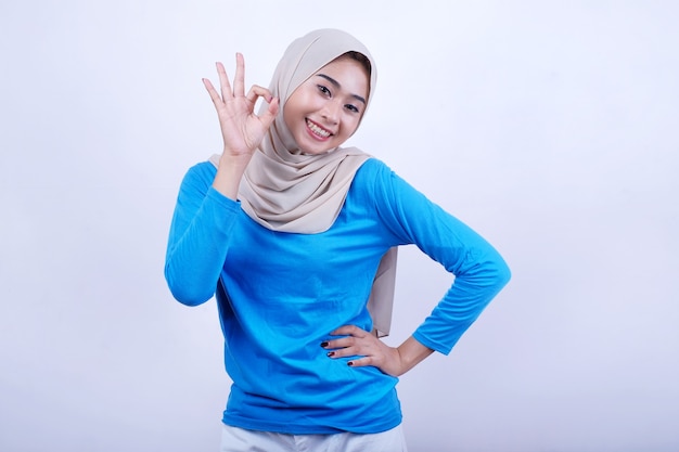 Belle femme portant un t-shirt bleu et hijab donne une expression correcte