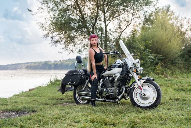 Belle femme posant avec casque et moto