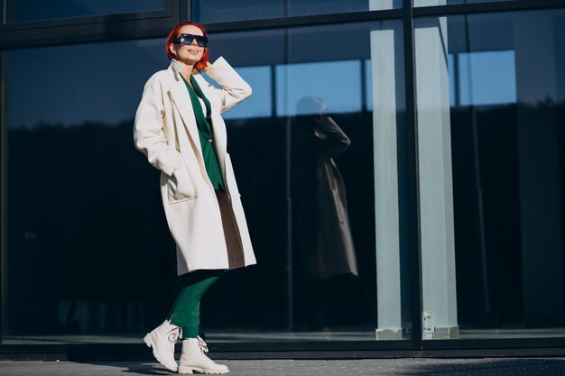 Belle femme posant en manteau d'automne posant dans la rue