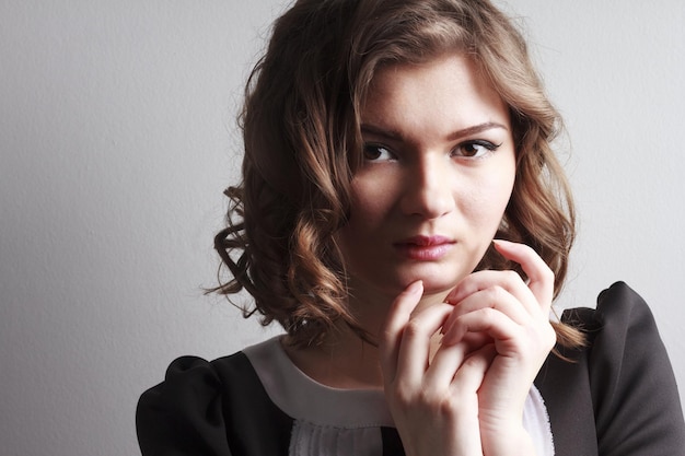 Belle femme posant en robe élégante sur les lunettes de fond gris studio Retouched