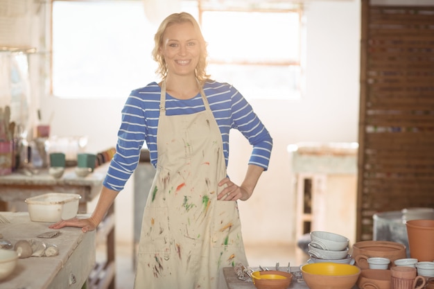 Belle femme potier debout dans un magasin de poterie