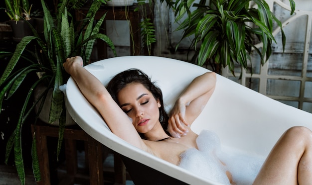 Belle femme prenant un bain chaud dans sa maison de campagne