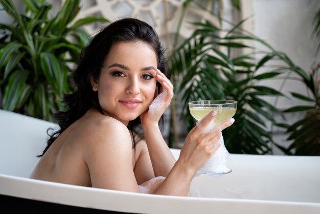 Belle femme prenant un bain chaud dans sa maison de campagne