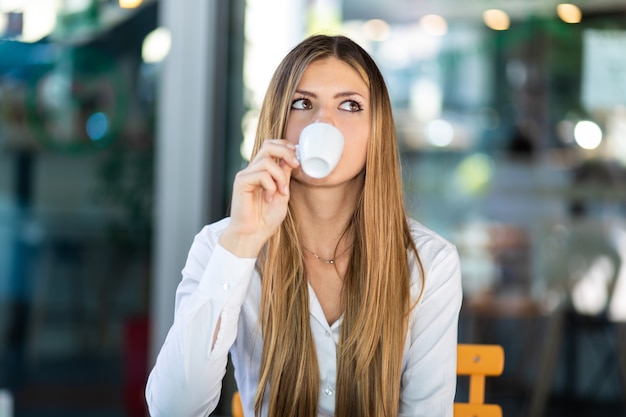 Belle femme prenant un café dans un café