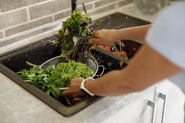 Belle femme prépare de délicieux plats dans sa cuisine à domicile