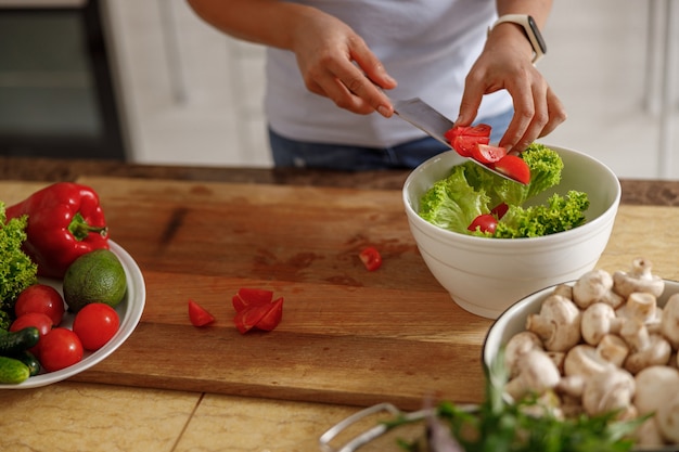 Belle femme prépare de délicieux plats dans sa cuisine à domicile