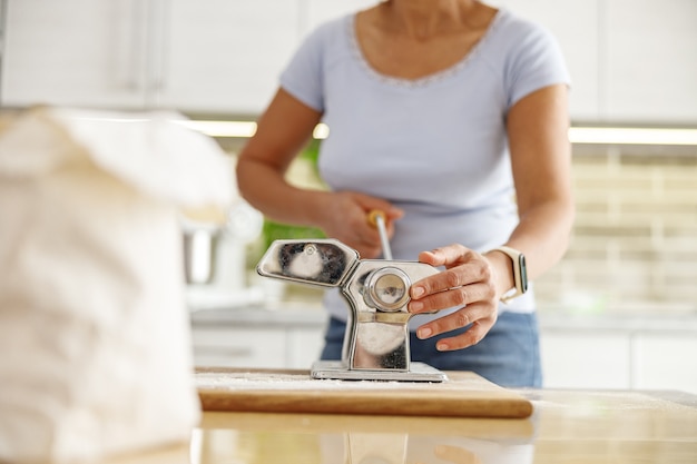 Belle femme prépare de délicieux plats dans sa cuisine à domicile