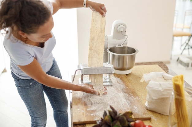 Belle femme prépare de délicieux plats dans sa cuisine à domicile