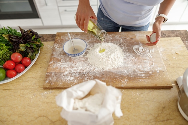 Belle femme prépare de délicieux plats dans sa cuisine à domicile